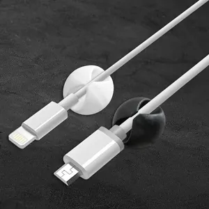 Close-up detail of round silicone cable organizers holding white data charging wires securely.