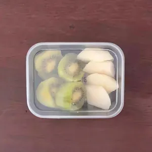 Transparent plastic food storage container displayed with sliced kiwi and pear fruit inside.