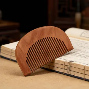 Natural peach wood hair comb with fine teeth, smooth handheld design for daily scalp massage.