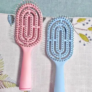 Detailed view of pink and blue curved macaron vent hair brushes for daily hair styling.