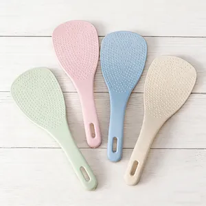 Vue détaillée de cuillères à riz antiadhésives en paille de blé aux couleurs pastel et picots.