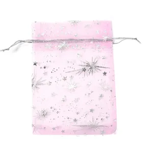 Dettaglio di sacchetto regalo in organza rosa con motivo stellato argento e coulisse.