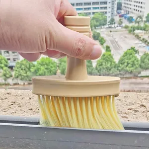 Detail view of a soft bristle cleaning brush clearing dust from window tracks and gaps easily.