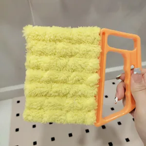 Handheld window blind cleaning brush with yellow plush head and orange handle for home use.