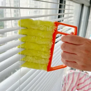 Detail view of the yellow plush blind cleaner brush cleaning window slats effectively.