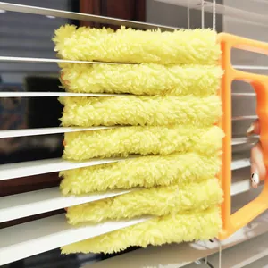 Detailed view of a yellow plush window blind cleaning brush with an orange handle for easy dust removal.