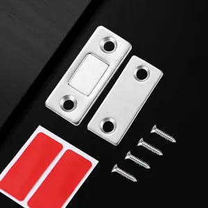 Detailed view of the magnetic cabinet door catch with metal plates, screws, and adhesive pads.