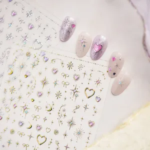 Detail shot of sparkly pink heart and gold star nail art stickers on press-on nails