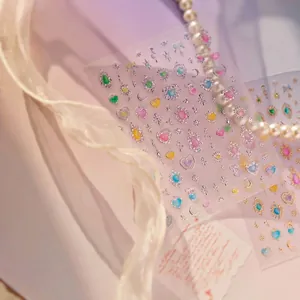 Close-up detail of glitter nail art stickers featuring heart and star patterns in soft light
