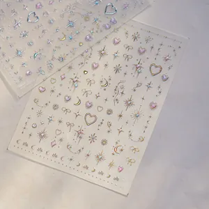 Detail shot of shimmering star and heart motif nail art stickers in gold and pink