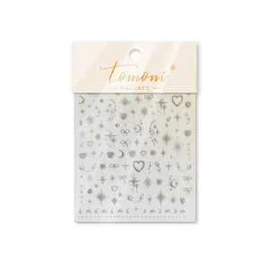 Close-up of Tomoni nail art stickers with glitter stars, hearts and moon patterns.