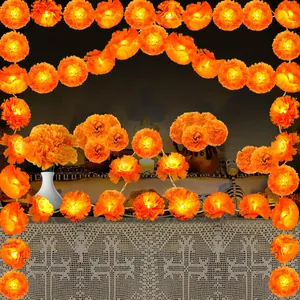 Close-up of glowing orange marigold flower garlands arranged in a festive altar setting