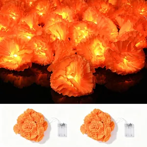 Detail view of orange marigold LED lights and clear battery box for decoration