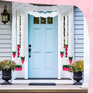Artificial jasmine garlands and pink lotus buds decorating a front door for Diwali.