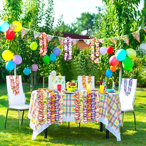 Hawaiian flower leis used as colorful party decorations in an outdoor garden setting