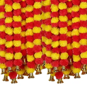 Close-up detail of vibrant red and yellow artificial marigold garlands with gold bells.