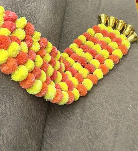 Close-up of artificial marigold flower garland with golden bells for Day of the Dead