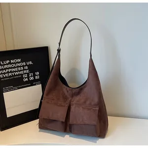 Brown suede shoulder bag with dual front pockets, stylish retro hobo tote for women daily use.