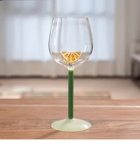 Close-up of a creative crystal wine glass featuring a 3D lemon slice and green stem.