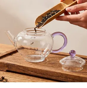 Détail de feuilles de thé versées dans une théière en verre résistante à la chaleur