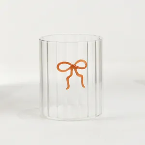 Tazza in vetro a costine con fiocco arancione, bicchiere da tè trasparente di classe.