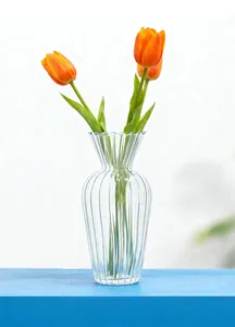 Vaso in vetro scanalato moderno con tulipani su tavolo blu decorazione minimalista