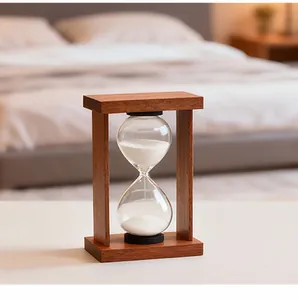 Vintage wooden frame glass hourglass with white sand on a minimalist white surface