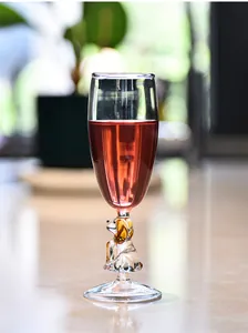 Close-up of a vintage champagne flute with a cute dog-shaped glass stem and red wine.