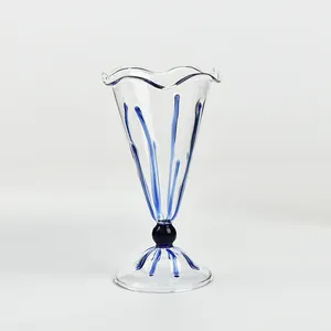 Elegante copa de vidrio transparente con borde ondulado y rayas azules para champán