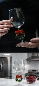 Dettaglio di un calice da vino natalizio con ghirlanda e fiocco rosso sullo stelo