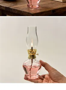 Macro detail of a vintage handmade adjustable glass oil lamp lit with pink fuel