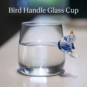 Kreative transparente Glastasse mit einem einzigartigen blauen vogel-förmigen Griff