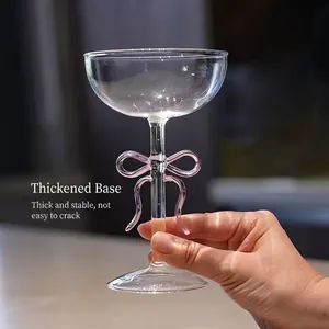 Creative bow tie wine glass with a pink glass ribbon on the stem, hand-held shot