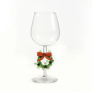 Elegante calice da vino natalizio con ghirlanda, fiocco rosso e decori festivi