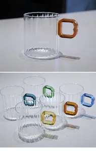 Detail view of striped glass mugs with colorful square handles for latte coffee