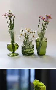 Elegant collection of three green ribbed glass vases in diverse artistic silhouettes for home decor