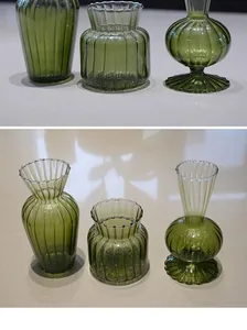 Close-up of three vintage green ribbed glass vases with elegant vertical stripes