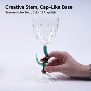 Handgemaakt creatief wijnglas met kleurrijke stippen en een steel in de vorm van een vis