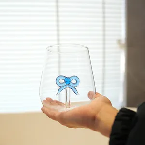 Elegant clear glass drinking cup featuring a unique blue handmade bow inside decoration