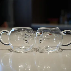 Set of two creative funny glass mugs with 3D human face relief design for coffee