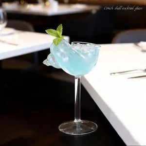 Elegant conch shell shaped cocktail glass with high stem in professional restaurant scene