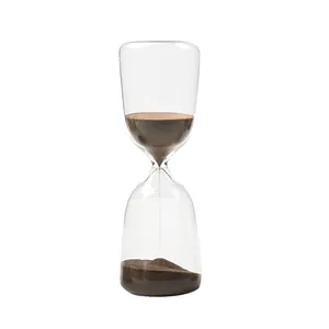 Minuterie sablier en verre de style nordique avec sable brun sur fond blanc neutre