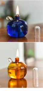 Two stylish spherical glass oil lamps in blue and amber colors with elegant lit flames