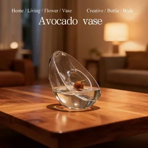 Avocado shaped glass hydroponic vase on a wooden table with warm ambient lighting