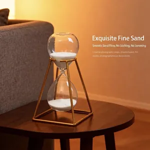Nordic golden metal frame hourglass timer with white sand on a wooden table