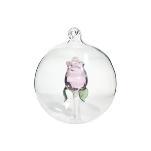 Elegant clear glass Christmas ornament ball featuring a delicate pink glass rose inside