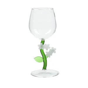 Eleganter Weinglas-Kelch mit grünem Pflanzenstiel und weißen Glasblüten