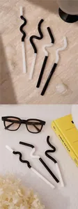 Set of artistic curved black and white reusable glass straws for creative drinks