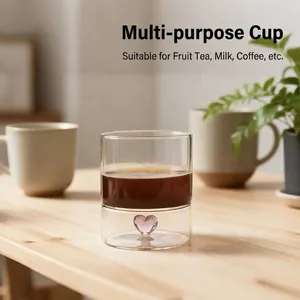 Macro view of a clear glass coffee cup featuring a delicate pink 3D heart in the base
