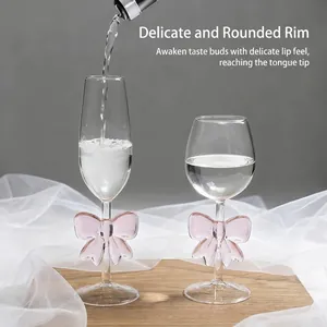 Elegant borosilicate glass wine glasses with pink bow-tie accents for romantic dining.